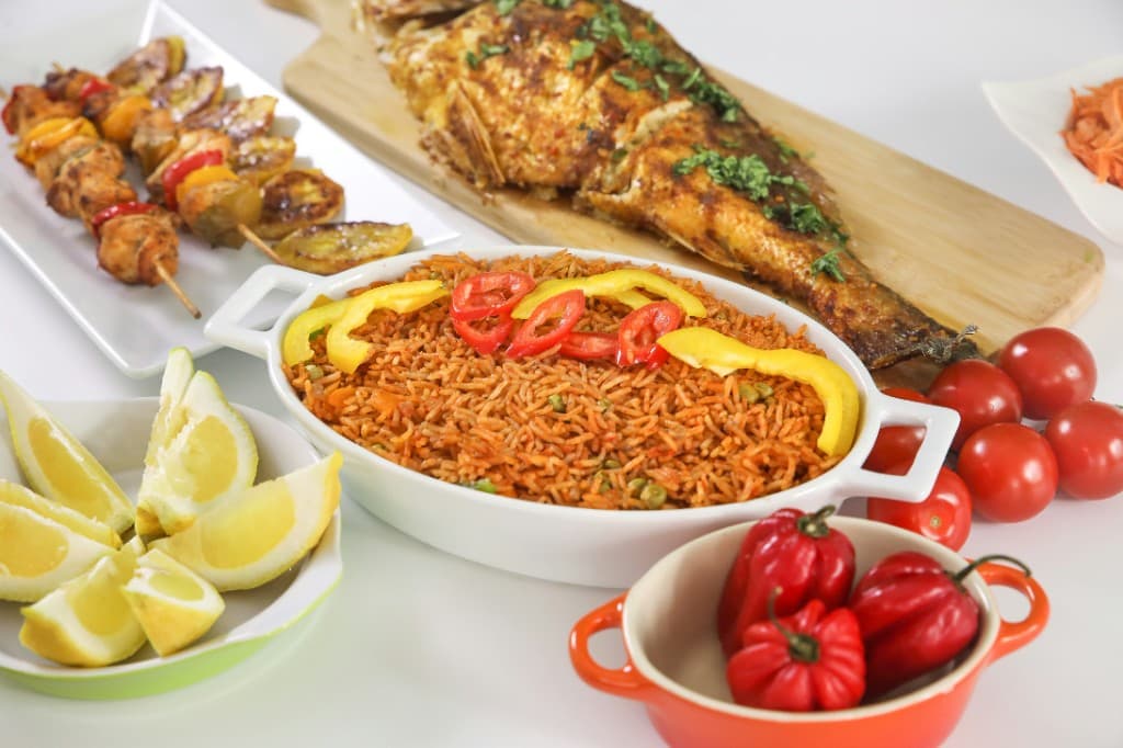 Nigerian meal spread - jollof, grilled fish, skewers